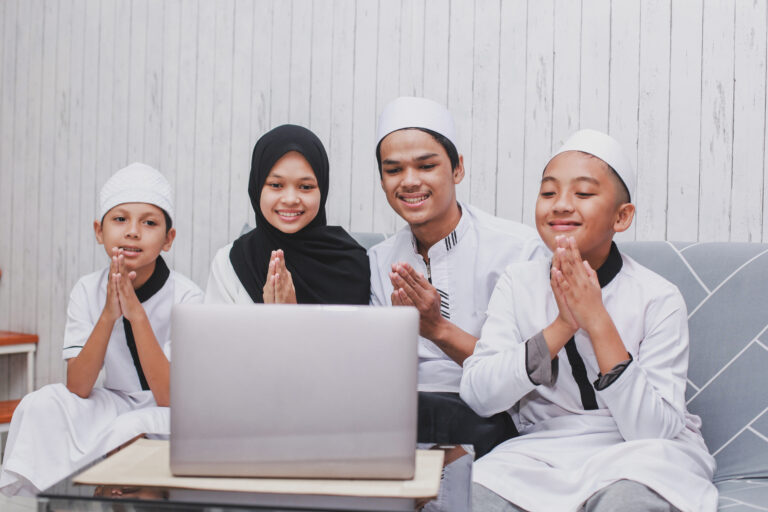 Children smiling during a live online Quran class at home